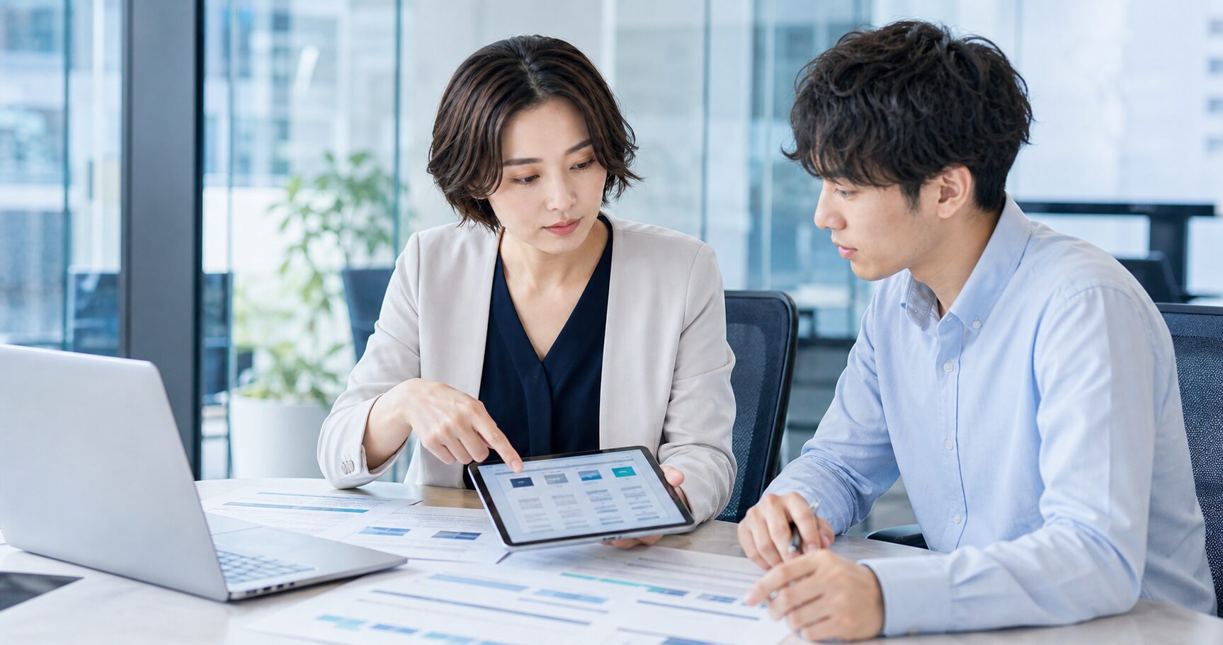 法人口座の条件を比較する経営者と経理担当者